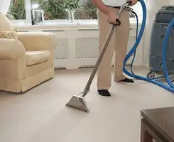 Carpet cleaning professional removing dirt and stains with a hot-water extraction tool in a home, El Paso, TX.